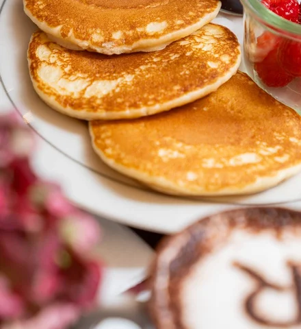 Pancakes with raspberries and a cappuccino topped with the RITRÒ R